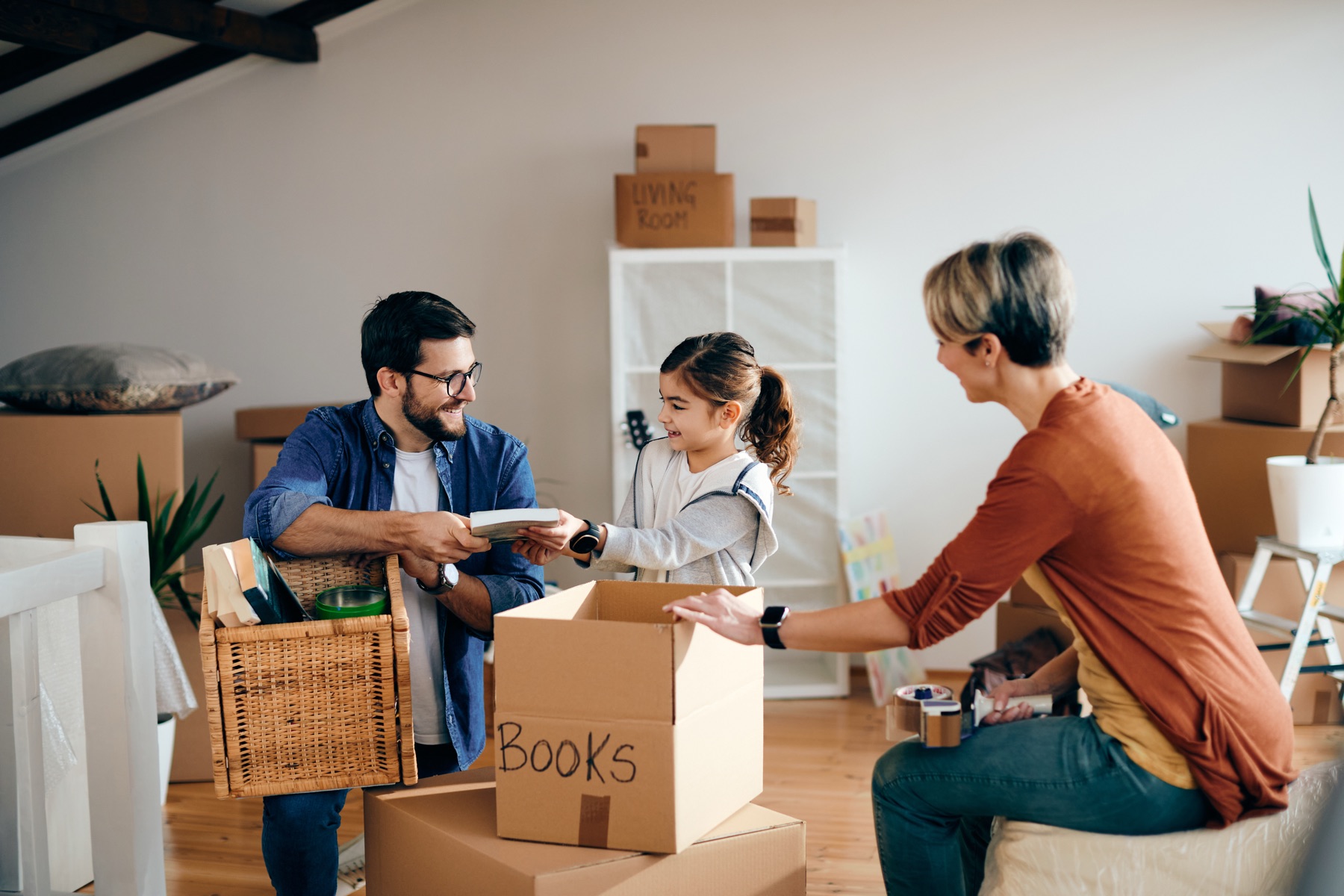 Family unpacking moving boxes together in their new home