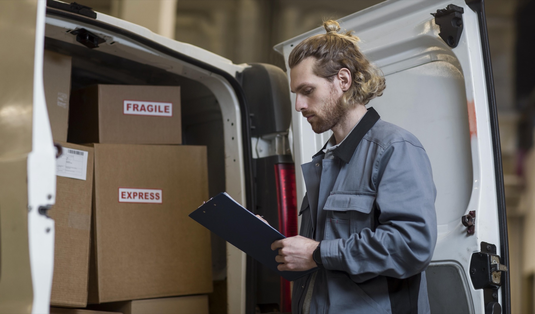 Mover checking his list beside a loaded moving van