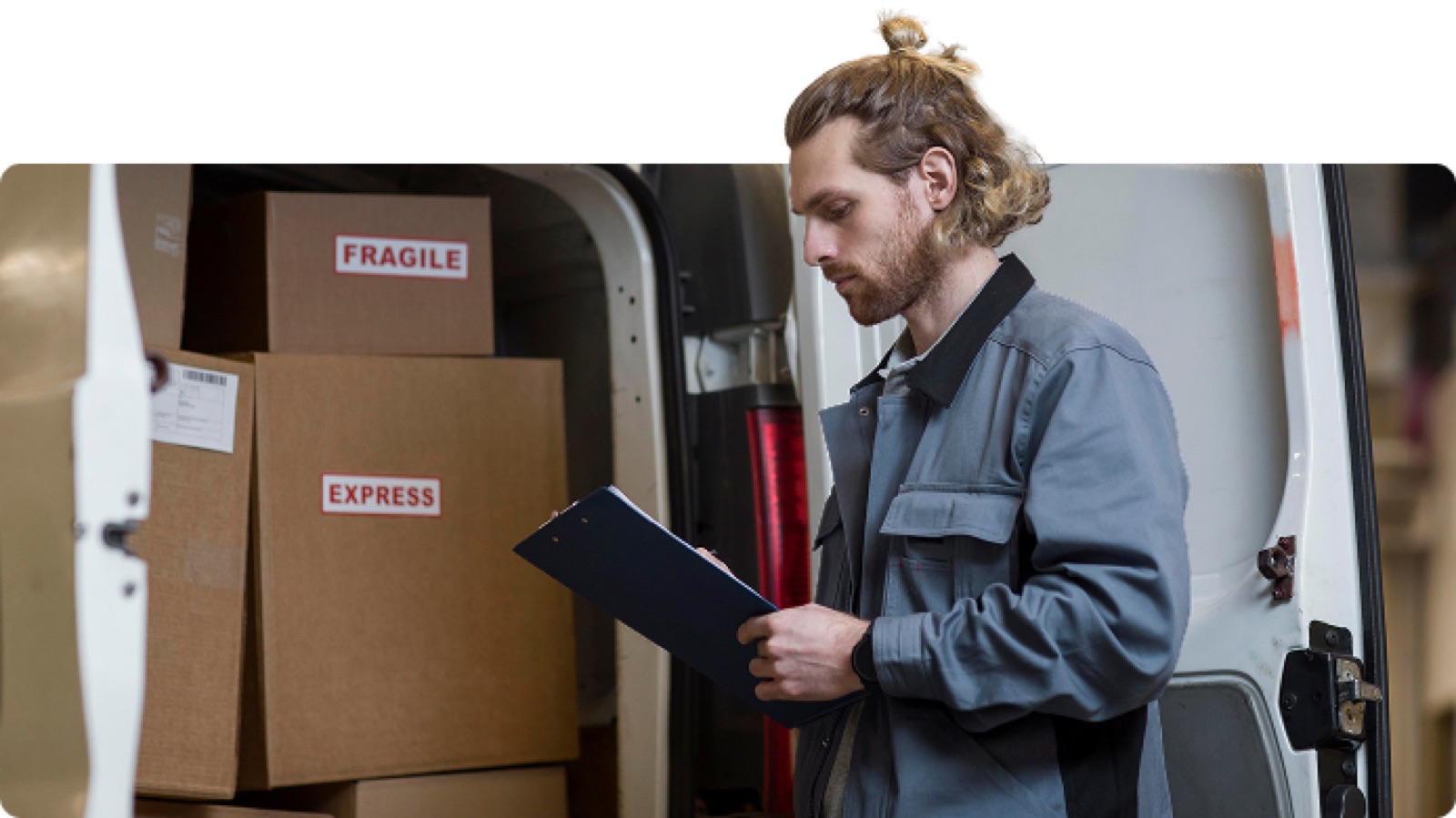 Mover with a clipboard beside a loaded van